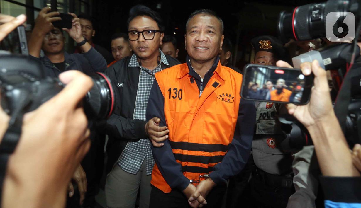 Bupati Tulungagung, Gatut Sunu Wibowo (tengah) dibawa petugas menuju mobil tahahan usai menjalani pemeriksaan intensif di Gedung Merah Putih Komisi Pemberantasan Korupsi (KPK), Jakarta, Minggu (12/4/2026) dini hari WIB. Komisi Pemberantasan Korupsi (KPK) resmi menahan Bupati Tulungagung, Gatut Sunu Wibowo beserta ajudannya, Dwi Yoga Ambal. (Liputan6.com/Helmi Fitrhiansyah)