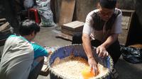 Ayep (63), perajin tempe tengah mengolah kedelai di Komplek Kopti RT 02 RW 10, Kelurahan Margahayu Utara, Kecamatan Babakan Ciparay, Kamis (31/12/2020). (Liputan6.com/Huyogo Simbolon)
