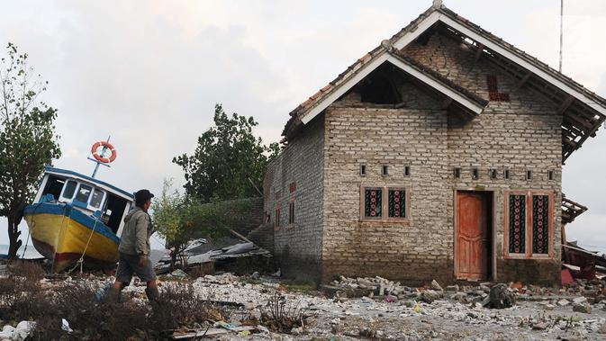 Seorang warga mengecek kondisi rumah yang ditinggalkan di dusun Regahan Lada, Pulau Sebesi, Lampung, Senin (31/12). Banyak warga dusun ini yang bertahan di lokasi pascatsunami yang melanda Selat Sunda pada 22 Desember lalu. (Liputan6.com/Herman Zakharia)
