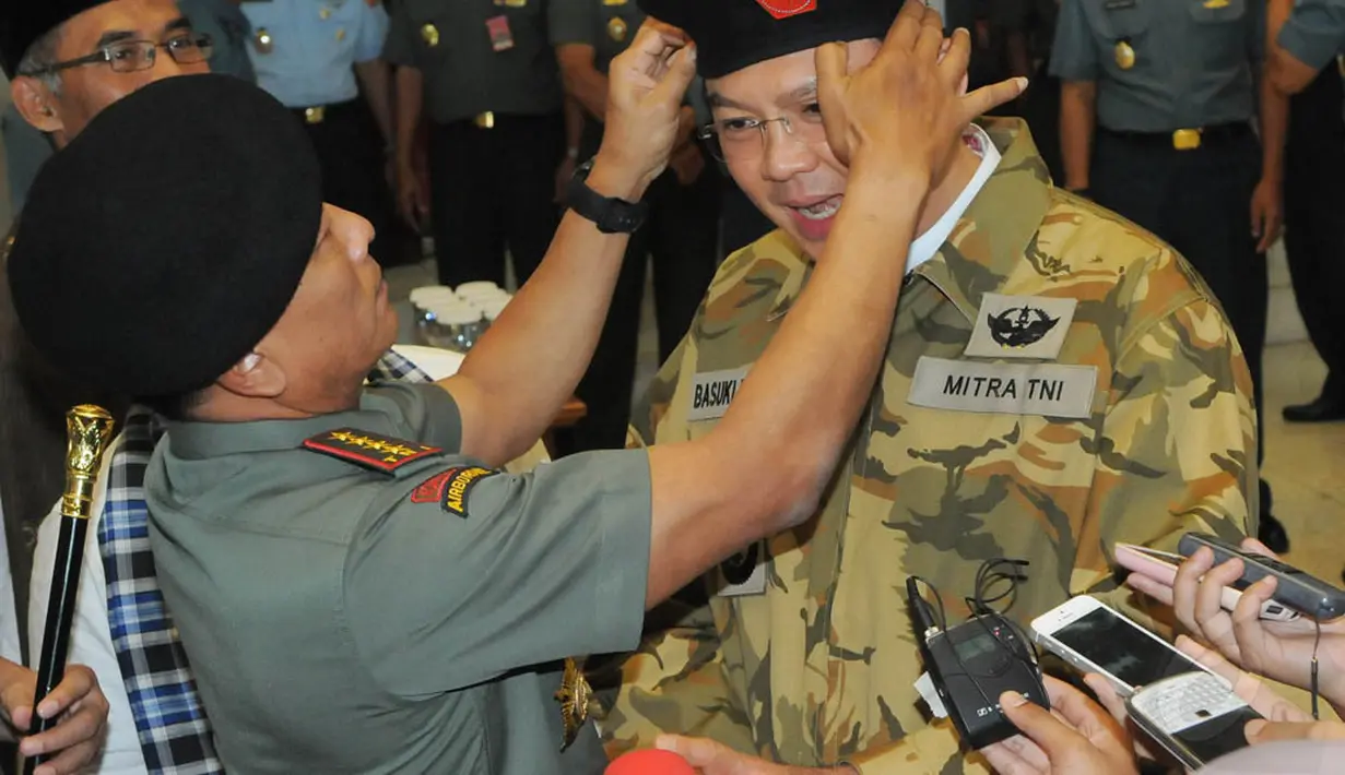Jenderal Moeldoko saat memperbaiki posisi baret Ahok, Jumat (12/12/2014). (Liputan6.com/Herman Zakharia)