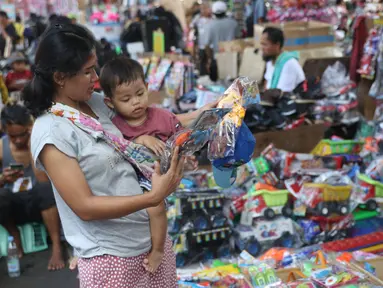 Pembeli melihat mainan produk China di Pasar Pagi Jakarta, Rabu (29/1/2020). Kasubdit Komunikasi Bea dan cukai, Deni Surjantoro mengatakan hingga kini belum ada barang dari China yang masuk ke Indonesia terindikasi membawa virus-virus aneh setelah mewabahnya virus corona. (Liputan6.com/Angga Yuniar)