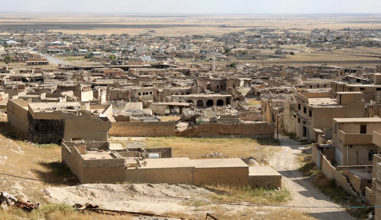 Bangunan-bangunan yang rusak akibat serangan militan Negara Islam (ISIS) tahun 2014 dan pertempuran setelahnya, berdiri di kota Sinjar di provinsi Nineveh, Irak utara, pada 6 Mei 2024. (Safin HAMID / AFP)