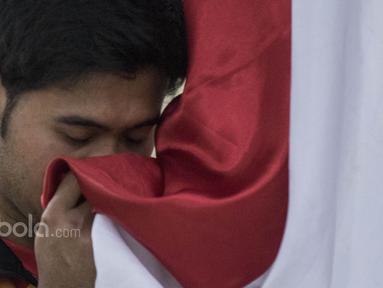 Pebulutangkis ganda putra Indonesia, Angga Pratama, mencium bendera saat seremoni pelepasan untuk Piala Sudirman di Kantor PBSI Cipayung, Jakarta, Sabtu (6/5/2017). (Bola.com/Vitalis Yogi Trisna)