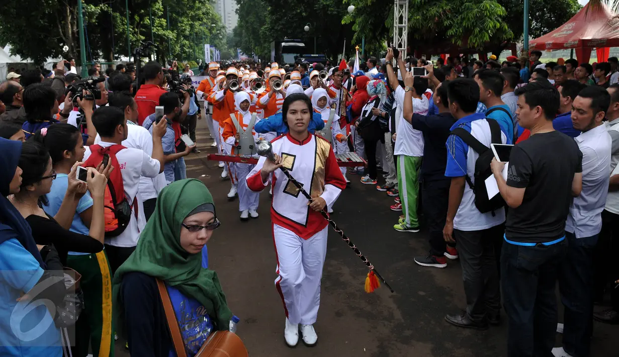 Masyarakat menyaksikan Parade Asean Games 2018 Jakarta - Palembang, di Plaza Selatan, Senayan, Jakarta, Minggu (27/12/2015). Indonesia akan menjadi tuan rumah perhelatan Asian Games 2018 mendatang. (Liputan6.com/Johan Tallo)