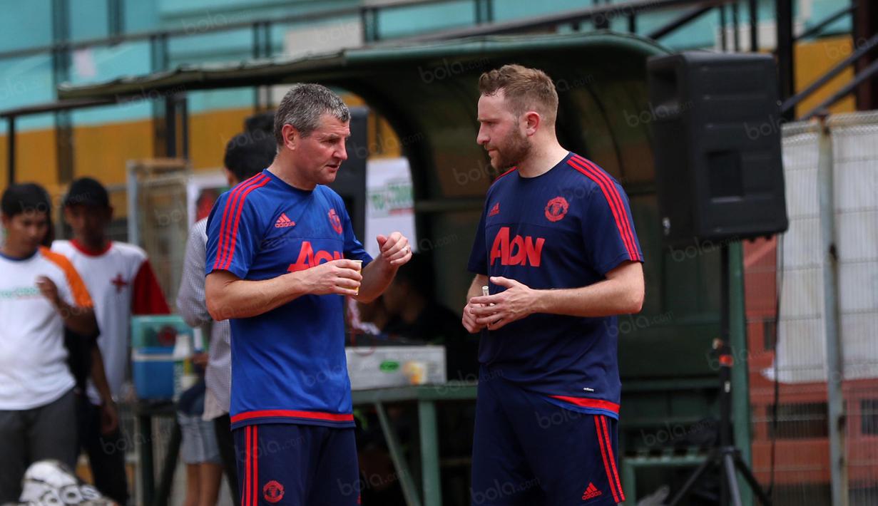 Legenda Manchester United, Denis Irwin (kiri),  berdiskusi dengan anggota tim pelatih MU pada acara United Way Coaching Clinic You C 1000 di Stadion Soemantri Brojonegoro, Jakarta, Sabtu (7/5/2016). (Bola.com/Nicklas Hanoatubun)
