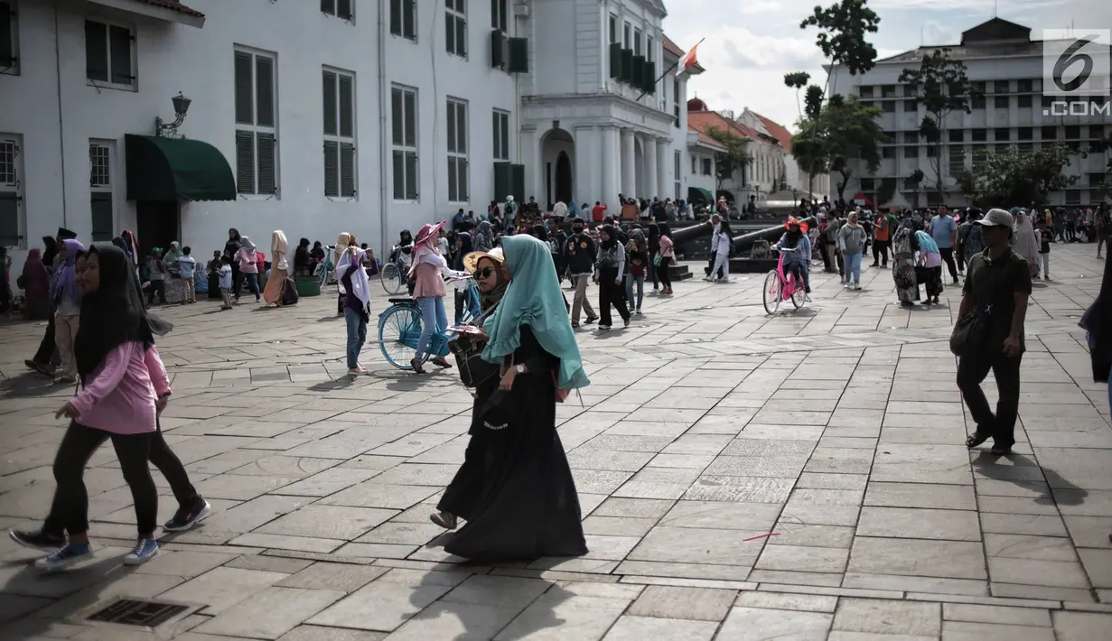 Pengunjung berwisata di depan Museum Sejarah Kota Tua, Jakarta, Kamis (27/12). Kawasan wisata Kota Tua dipadati wisatawan dari dalam kota maupun luar kota Jakarta selama libur sekolah. (Liputan6.com/Faizal Fanani)