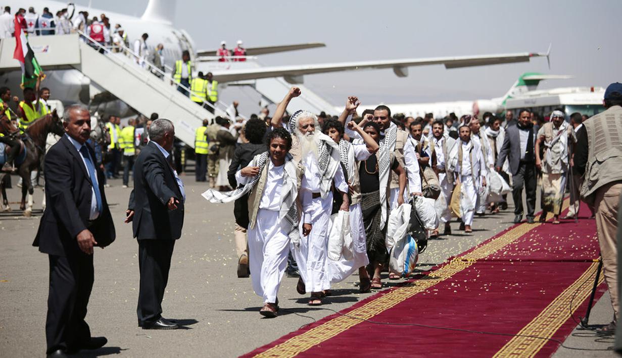 Tahanan Yaman meneriakkan slogan selama kedatangan mereka setelah dibebaskan oleh koalisi pimpinan Arab Saudi di bandara di Sanaa, Yaman, Jumat (16/10/2020). Pihak yang bertikai di Yaman menyelesaikan pertukaran tahanan besar yang ditengahi PBB pada hari Jumat. (AP Photo/Hani Mohammed)