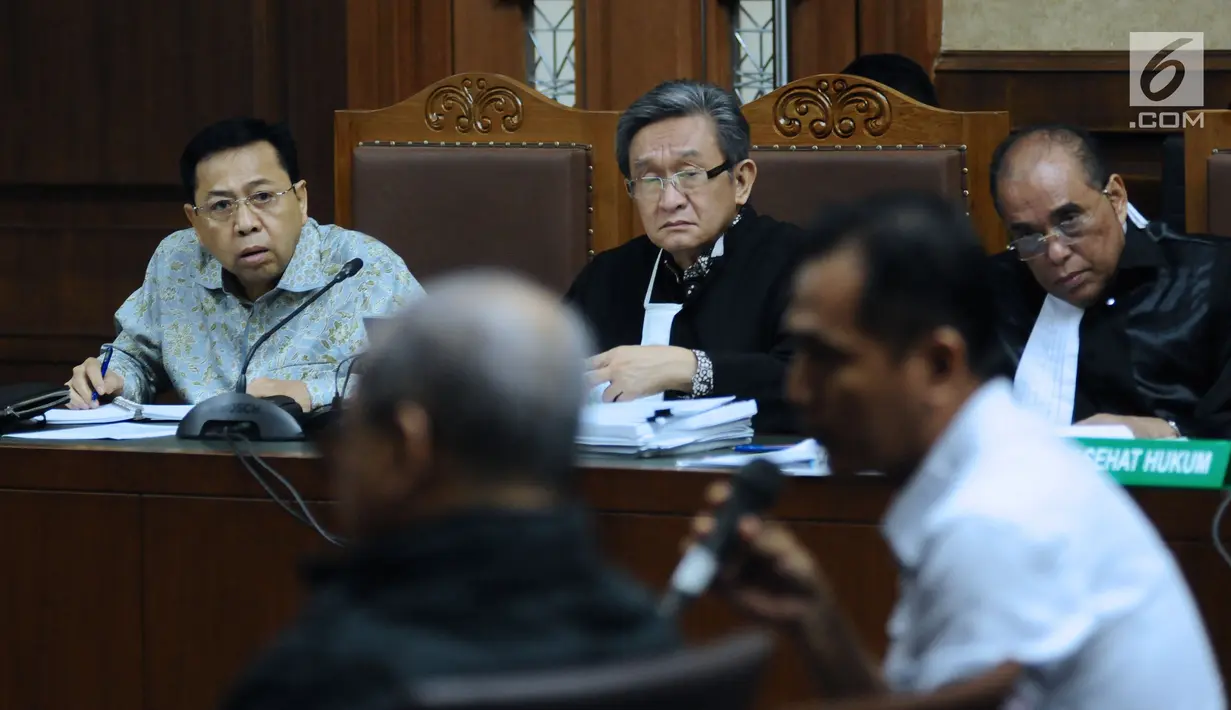 Terdakwa dugaan korupsi proyek e-KTP, Setya Novanto (kiri) menyimak keterangan saksi pada sidang lanjutan di Pengadilan Tipikor, Jakarta, Senin (12/3). Sidang mendengar keterangan saksi dan saksi ahli. (Liputan6.com/Helmi Fithriansyah)