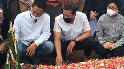 Joko Riyadi (tengah) rekan Markis Kido sesama mantan pebulutangkis PBSI nomor ganda putra menatap haru pusara makam sahabatnya yang harus mendahuluinya terlebih dahulu. (Foto: Bola.com/Erwin Fitriansyah)