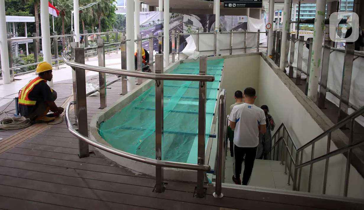 Pekerja menyelesaikan pengerjaan anjungan Halte Transjakarta Bundaran HI saat uji coba anjungan itu di kawasan Bundaran Hotel Indonesia, Jakarta, Senin (10/10/2022). Lokasi tersebut jadi spot foto baru dengan latar belakang Patung Selamat Datang dan air mancur Bundaran HI. (Liputan6.com/Johan Tallo)