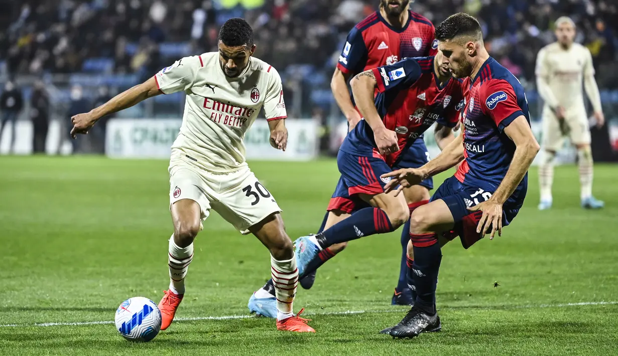 Gelandang AC Milan, Junior Messias (kiri) mengontrol bola dari kawalan bek Cagliari, Giorgio Altare (kanan) selama pertandingan Liga Serie A Italia di Sardegna Arena di Cagliari, Italia, Minggu (20/3/2022). AC Milan menang atas Cagliari 1-0. (AFP/Alberto Pizzoli)