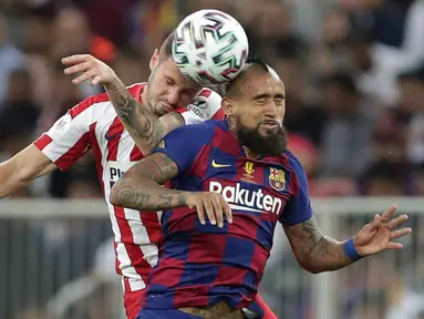 Gelandang Barcelona, Arturo Vidal melompat saat berebut bola dengan pemain Atletico Madrid, Saul pada laga semifinal Piala Super Spanyol di King Abdullah Sports City, Jeddah, Kamis (9/1/2020). Barcelona harus menjalani pertandingan yang dramatis saat kalah 2-3 dari Atletico Madrid. (AP/Hassan Ammar)