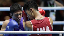 Petinju Indonesia, Grece Savon Simangunsong (merah) menangkis pukulan petinju Jepang, Hiroaki Kinjo pada semifinal Test Event Asian Games 2018 kelas Welter di Kemayoran, Jakarta (14/2/2018). Simangunsong menang dengan skor 3-2. (Bola.com/Nick Hanoatubun)