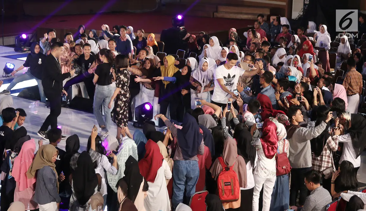 Para penonton mengambil gambar pemain film Buffalo Boys, Pevita Pearce dan Yoshi Sudarso saat gelaran Emtek Goes to Campus (EGTC) 2018 di Universitas Negeri Semarang (UNNES), Semarang, Kamis (19/7). (Liputan6.com/Herman Zakharia)