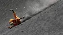 Seorang wisatawan terjatuh ketika bermain sandboarding atau berseluncur pasir menuruni gunung berapi Cerro Negro di Leon, Nikaragua, 24 September 2016. Gunung Cerro Negro salah satu gunung api yang masih aktif di Nikaragua. (INTI Ocon/AFP)