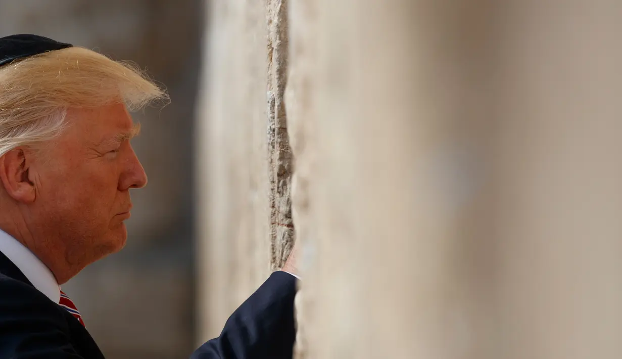 Presiden AS Donald Trump berdoa di Tembok Ratapan, tempat suci milik kaum Yahudi, di Yerusalem, Senin (22/5). Trump yang menganut Kristen Protestan, adalah presiden AS pertama yang mempunyai anggota keluarga inti orang Yahudi. (AP Photo/Evan Vucci)