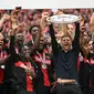 Xabi Alonso mengangkat trofi gelar juara Bundesliga bersama Bayer Leverkusen. (INA FASSBENDER / AFP)