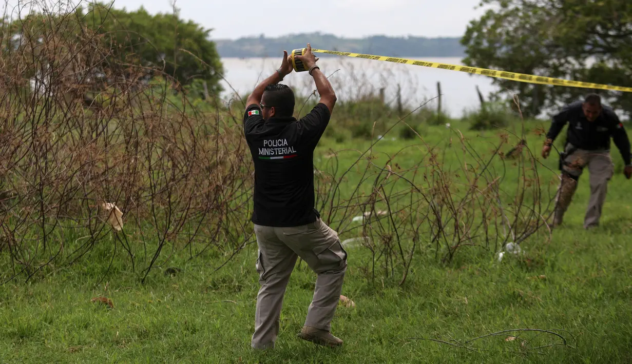 Polisi menutup daerah ditemukannya kuburan massal rahasia di Arbolillo, negara bagian Veracruz, Meksiko, Jumat (7/9). Jaksa Negara Bagian Veracruz, Jorge Winckler mengatakan mayat-mayat itu dikubur setidaknya sekitar dua tahun lalu. (AP/Felix Marquez)