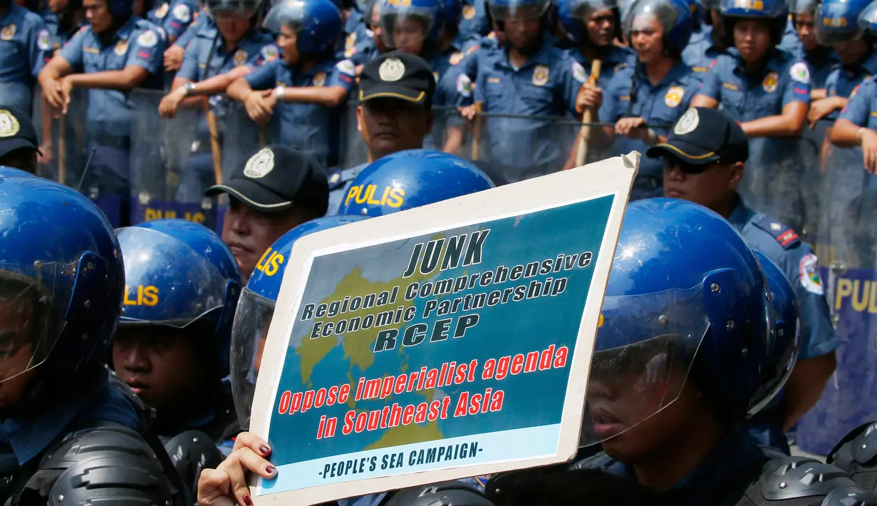 Polisi anti huru hara berjaga-jaga di depan Kedutaan Besar AS saat aksi protes berlangsung AS di Manila, Jumat (28/4). Demonstran mengecam imperealisme yang dilakukan oleh Amerika Serikat, Jepang dan China atas Asia Tenggara. (AP Photo / Bullit Marquez)