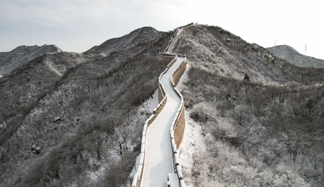 Foto ini menunjukkan pemandangan udara dari bagian Tembok Besar Cina yang tertutup salju di Shuiguan, sebelah utara Beijing, pada 15 Desember 2023. (GREG BAKER/AFP)