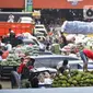 Aktivitas bongkar muat sayur dan buah-buahan di Pasar Induk Kramat Jati, Jakarta Timur, Minggu (12/4/2020). Kegiatan di pasar tersebut berjalan normal selama pandemi COVID-19, namun penjual dan pekerja masih terlihat belum mengenakan masker. (Liputan6.com/Johan Tallo)