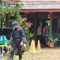 Polisi menggeledah rumah diduga dukun santet di kawasan Sawah Lama, Kecamatan Ciputat, Kota Tangerang Selatan (Tangsel). Dalam penggeledehan itu, polisi menemukan dua pucuk senjata api (senpi), sejumlah peluru, dan granat nanas. (Liputan6.com/Pramita Tristiawati)