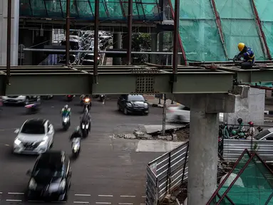 Kendaraan melintas dekat proyek pembangunan Jembatan layang (skybridge) CSW di Jakarta, Selasa (9/3/2021). Proyek pembangunan jembatan layang atau skybridge untuk integrasi Halte Transjakarta CSW di Stasiun MRT Asean ditargetkan selesai pada Mei 2021. (Liputan6.com/Johan Tallo)