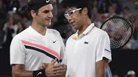 Petenis Swiss, Roger Federer (kiri), bersalaman dengan Hyeon Chung setelah laga semifinal Australia Terbuka 2018, di Melbourne, Jumat (26/1/2018). (AP Photo/Andy Brownbill)