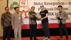 Direktur Bisnis Bank DKI,  Antonius Widodo Mulyono (tengah) dan CMO Go-Jek, Piotr Jakubowski (kedua kanan) tukar cinderamata usai penandatanganan kerjasama interoperabilitas uang elektronik dan perluasan channel pembayaran pajak. (Liputan6.com/Pool/Budi)