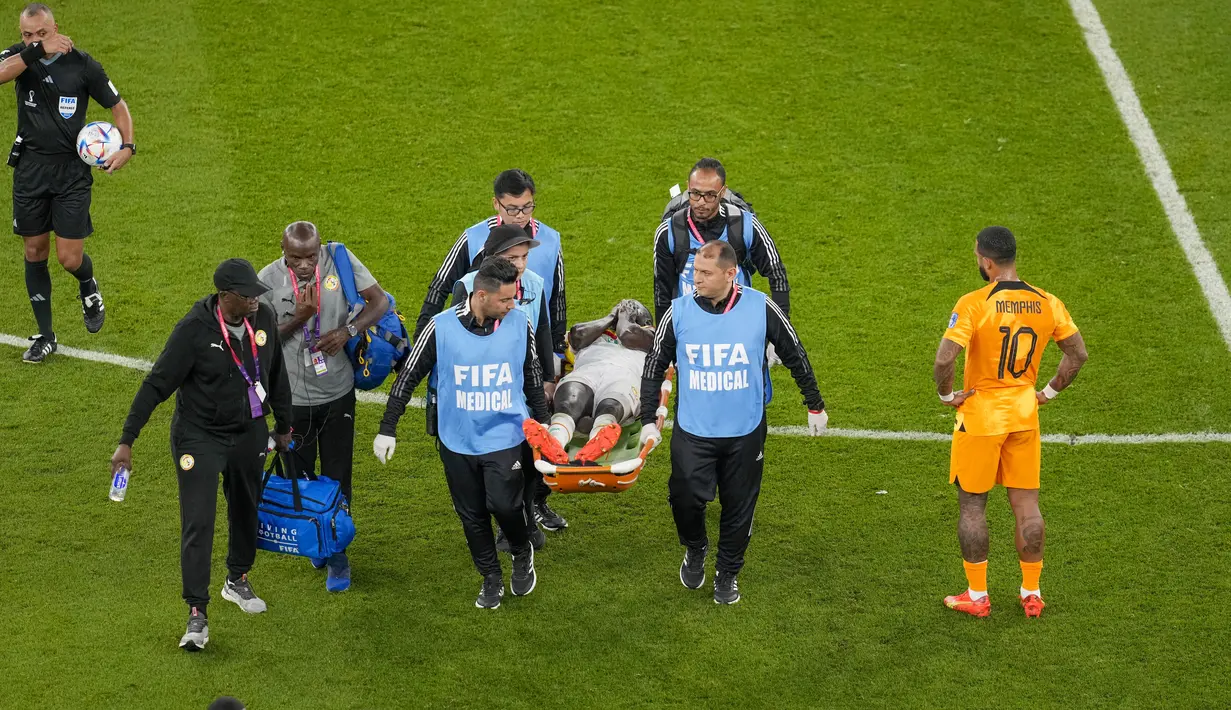 Gelandang Senegal Cheikhou Kouyate dibawa menggunakan tandu setelah mengalami insiden dengan gelandang Belanda, Frenkie de Jong pada pertandingan kedua Grup A Piala Dunia 2022 di Stadion Al-Thumama di Doha, Senin (21/11/2022). Kejadian itu membuat Kouyate langsung terkapar di lapangan dan tak mampu berdiri karena menahan rasa sakit di bagian kemaluan. (AP Photo/Thanassis Stavrakis)