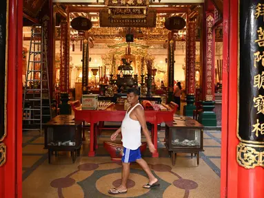 Seorang pria berjalan melewati kuil Tionghoa jelang Tahun Baru Imlek di Distrik Pecinan Yangon, Myanmar, 18 Januari 2023. Tahun Baru Imlek 2023 yang disebut sebagai Tahun Kelinci akan jatuh pada tanggal 22 Januari. (STRINGER/AFP)