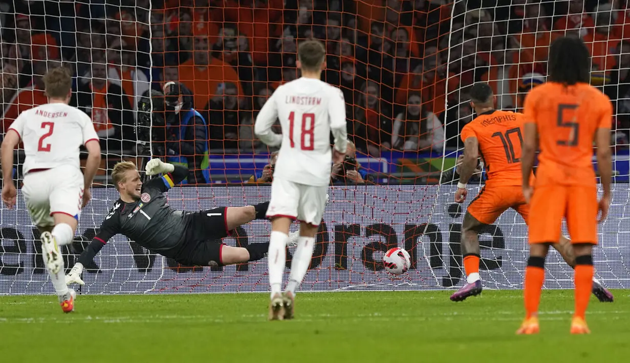 Pemain Belanda Memphis Depay (kedua kanan) mencetak gol dengan penalti melewati kiper Denmark Kasper Schmeichel pada pertandingan persahabatan di Johan Cruyff ArenA, Amsterdam, Belanda, 26 Maret 2022. Belanda menang 4-2. (AP Photo/Peter Dejong)