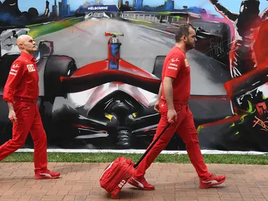 Anggota tim Ferrari tiba untuk mengepak peralatan mereka setelah Formula 1 Australia dibatalkan di Melbourne, Jumat (13/3/2020). F1 Australia batal digelar karena virus corona COVID-19. (William WEST/AFP)