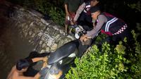 Warga dan Anggota Samapta Polres Bangkalan saat mengevakuasi sepeda motor korban begal yang masuk ke selokan. (Foto istimewa)