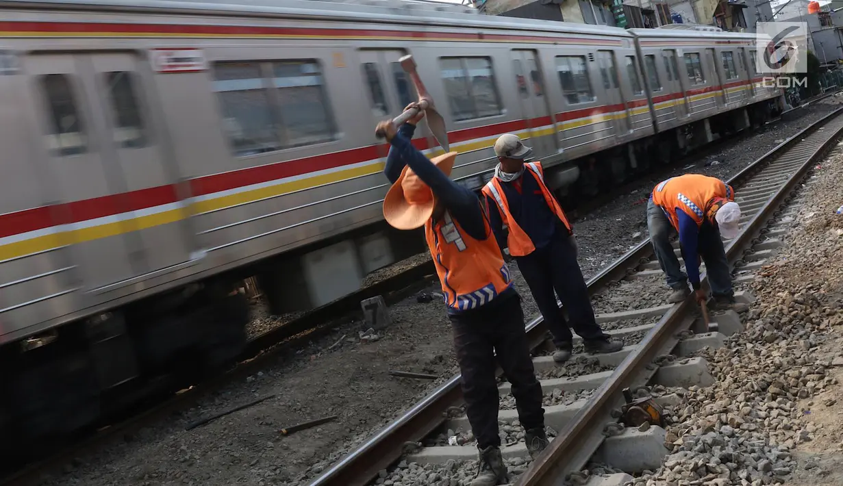 Pekerja menambahkan kerikil pada bantalan rel kereta di kawasan Roxy, Jakarta, Selasa (7/1). Penambahan kerikil tersebut dilakukan sebagai bentuk perawatan rutin agar perjalanan kereta tetap aman dan lancar. (Liputan6.com/Immanuel Antonius)