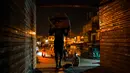 Seorang buruh mengangkat sekarung barang di kawasan tua New Delhi, India (6/3). Karena tuntutan ekonomi para buruh India ini harus rela hidup seadanya, bahkan mereka masih bekerja hingga larut malam. (AFP Photo/Chandan Khanna)