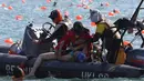 Perenang yang kelelahan diselamatkan petugas ketika lomba renang lintas pelabuhan berjarak 1.500 meter di Hong Kong, Minggu (16/10). Sejumlah peserta lomba renang tahunan Lintas Pelabuhan Hong Kong mengalami kelelahan dan tenggelam. (REUTERS/APPLE DAILY)