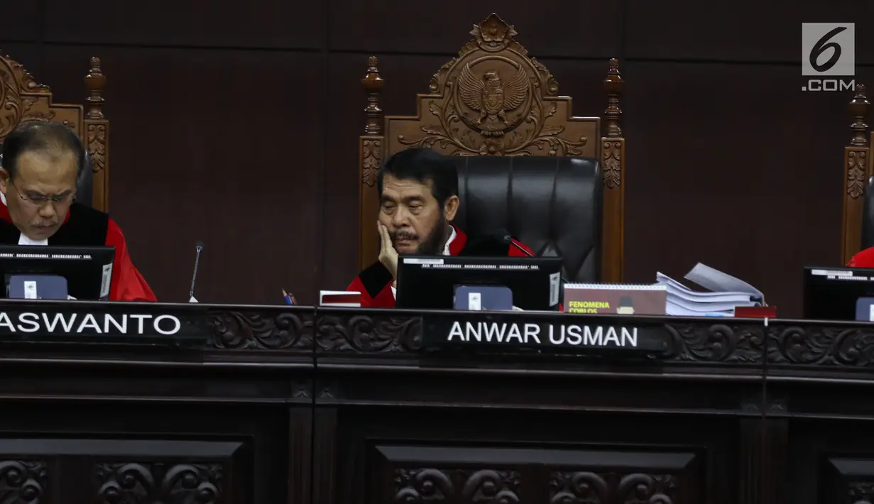 Ketua Majelis Hakim Mahkamah Konstitusi (MK) Anwar Usman mendengarkan tuntutan yang dibacakan tim kuasa hukum pasangan calon nomor urut 02 selaku pemohon pada sidang perdana sengketa Pilpres 2019 di Mahkamah Konstitusi, Jakarta, Jumat (14/6/2019). (Lputan6.com/Johan Tallo)
