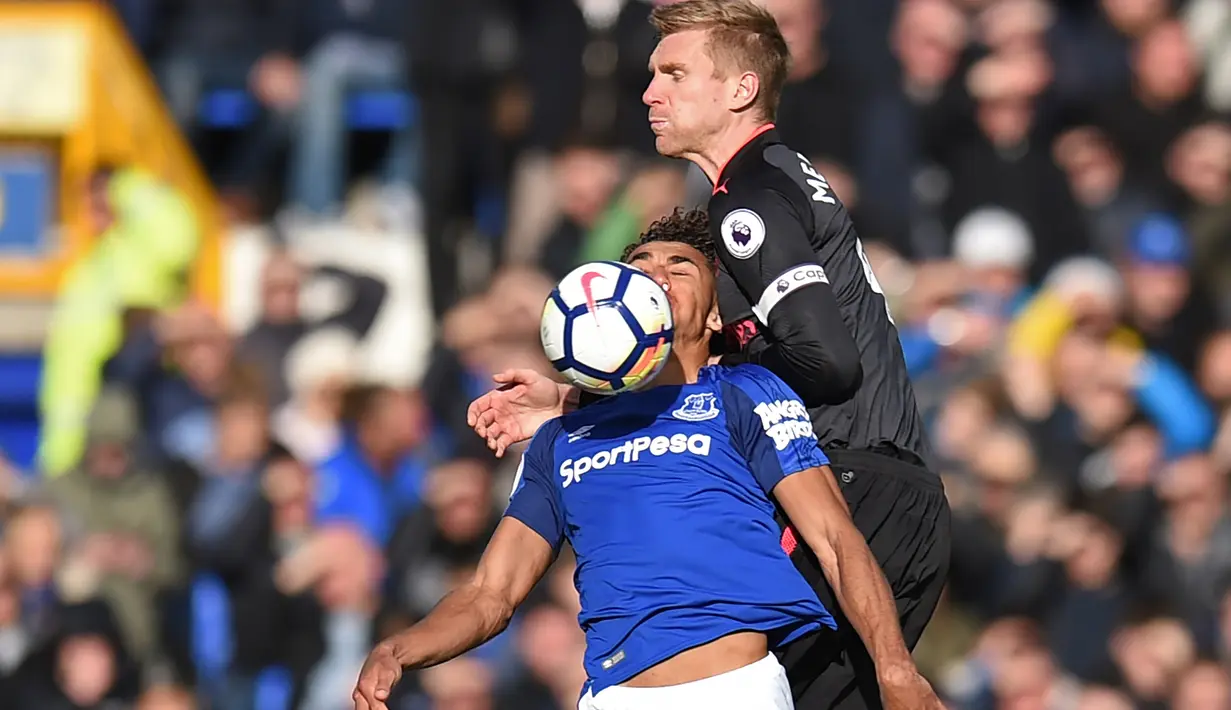 Pemain Everton,  Dominic Calvert-Lewin (kiri) berebut bola dengan pemain Arsenal, Per Mertesacker (kanan) pada laga Premier League pekan ke-9 di Goodison Park, Liverpool, (22/10/2017). Arsenal menang 5-2. (AFP/Oli Scarff)