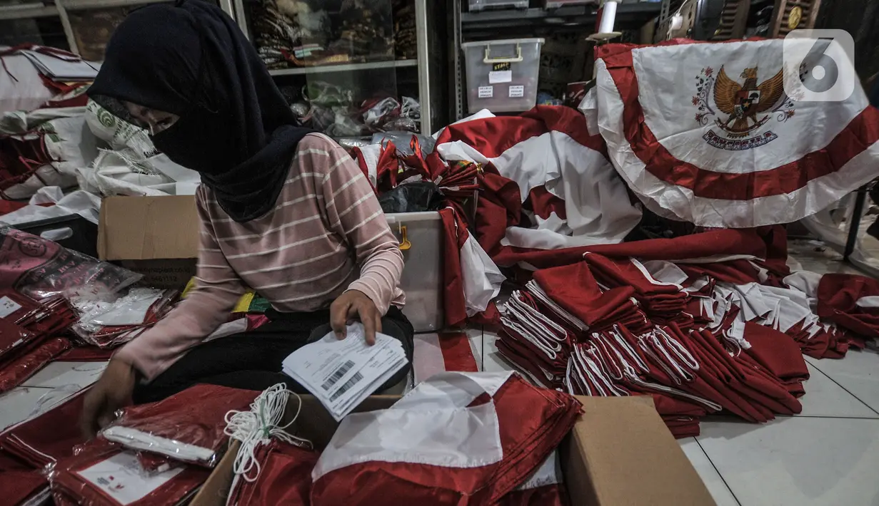 Pekerja mengemas bendera Merah Putih untuk diikirim melalui jasa kurir di industri rumahan benderaindonesia.com, Jakarta, Selasa (3/8/2021). Andri (56) seorang pemilik toko bendera online ini mengaku dalam sehari mampu menjual hingga 100 buah bendera Merah Putih. (merdeka.com/Iqbal S Nugroho)