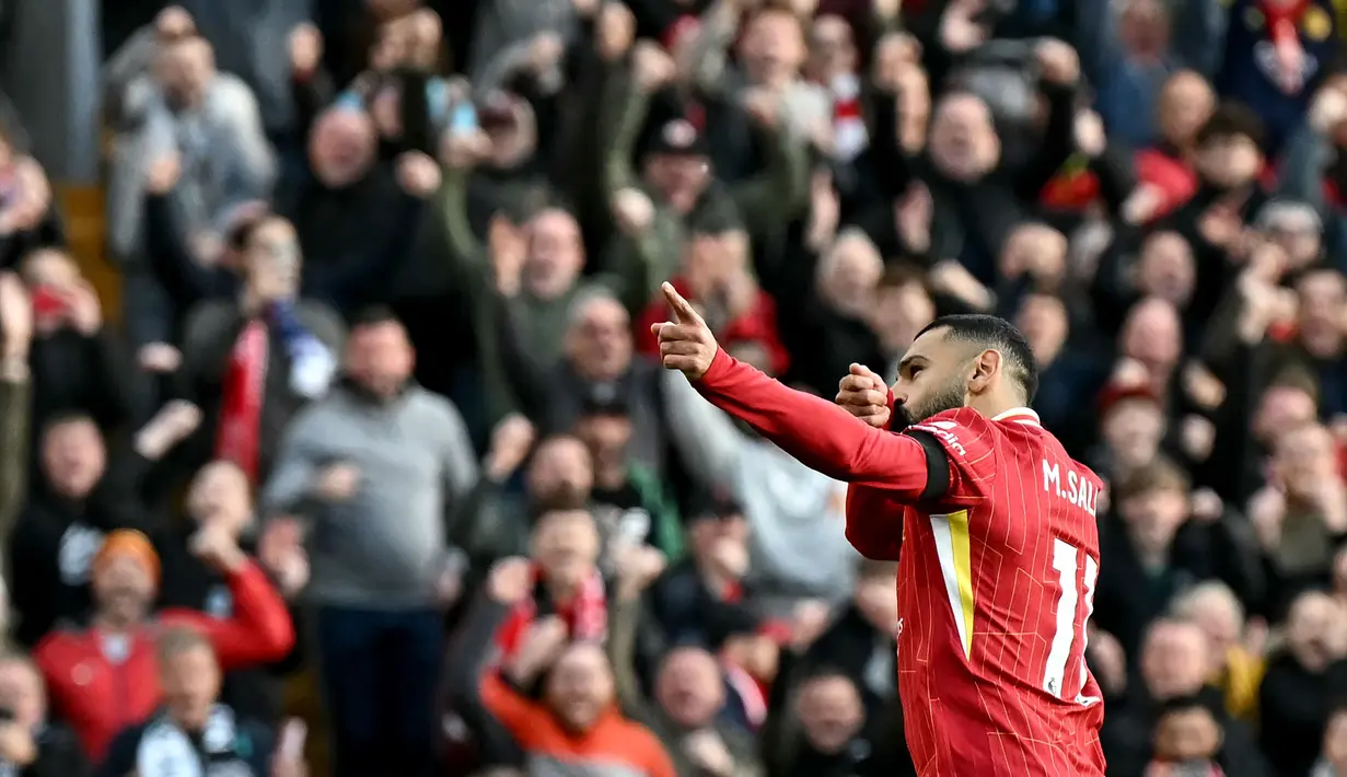 Pemain Liverpool, Mohamed Salah melakukan selebrasi setelah mencetak gol pertama timnya melalui tendangan penalti pada laga lanjutan Liga Inggris 2024/2025 melawan Chelsea di Anfield, Liverpool, Inggris, Minggu (20/11/2024). (AFP/Paul Ellis)