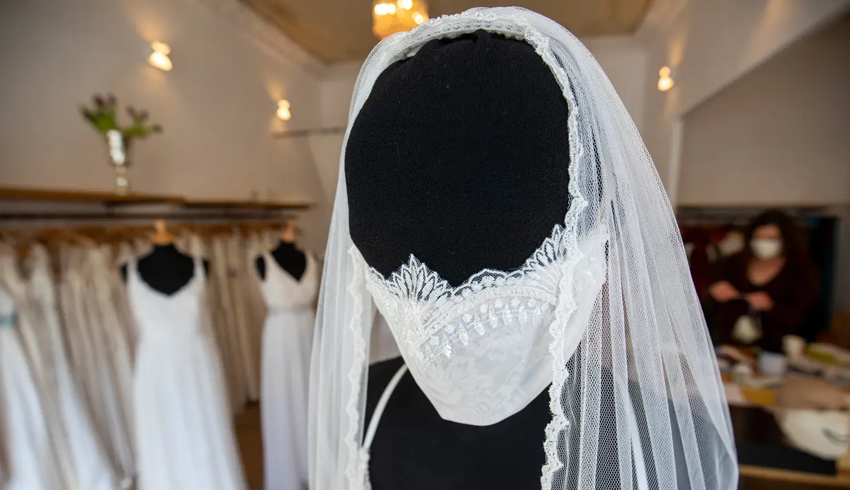 Gaun pernikahan lengkap dengan masker buatan desainer Friederike Jorzig terlihat di tokonya di Berlin, Jerman (31/3/2020).  Masker buatan Friederike Jorzig dibuat khusus bagi pasangan pengantin yang akan menikah di tengah pemberlakuan lockdown di Jerman. (AFP/Odd Andersen)