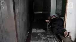 Pedagang tertidur di depan toko yang ditutup sementara di Pasar Perumnas Klender, Jakarta, Rabu (10/6/2020). Pasar Perumnas Klender terpaksa ditutup sementara setelah ditemukannya sebanyak 20 pedagang postif Covid-19. (merdeka.com/Iqbal S. Nugroho)