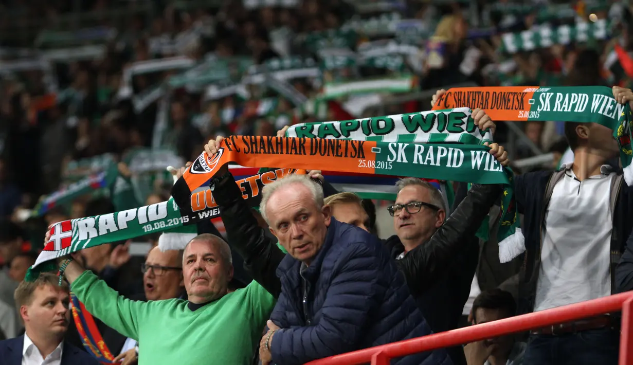 Fans Rapid Vienna membentangkan syal saat lagu himne tim kesayangannya diputar di Stadion Ernst Happel, Wina, Rabu (19/8/2015) malam waktu setempat. (Bola.com/Reza Khomaini)
