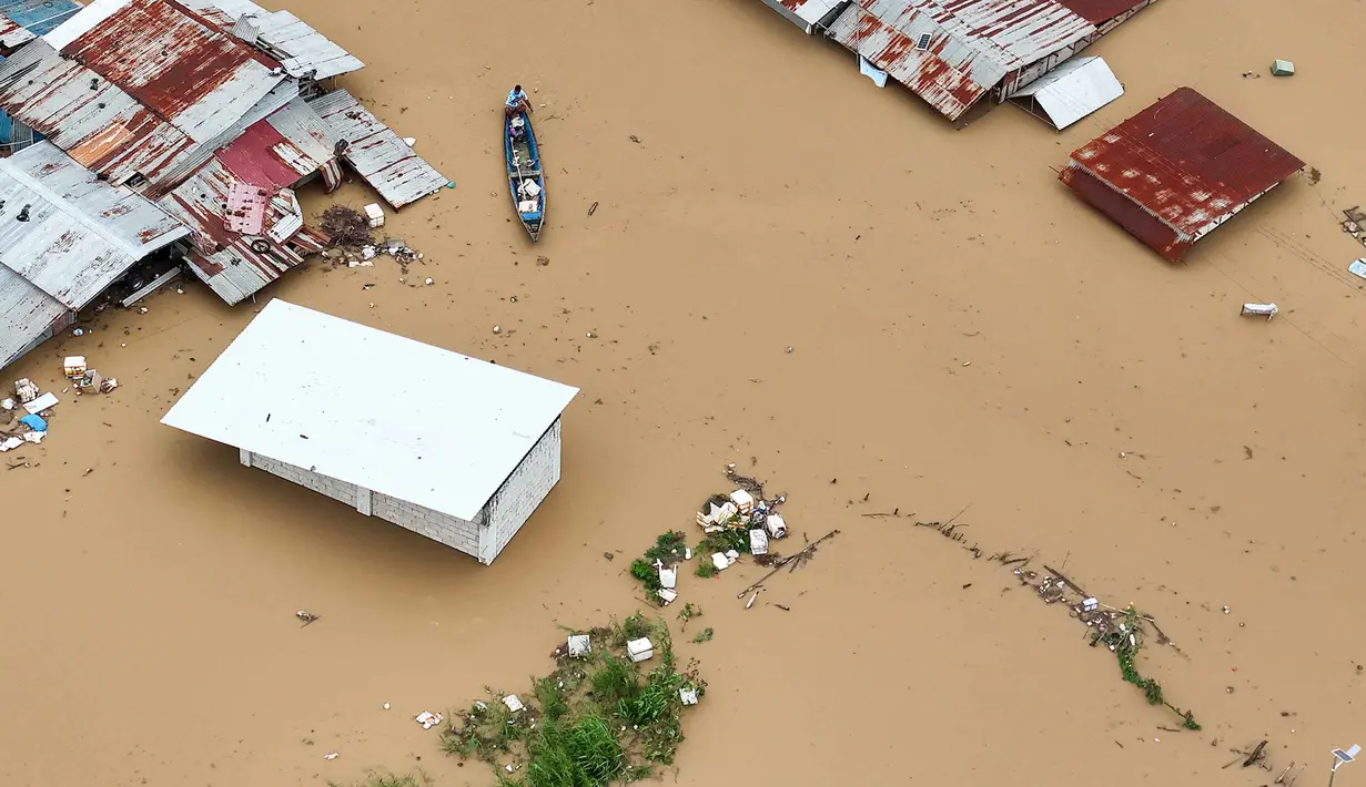 Topan Super Fung-wong merupakan badai tropis ke-21 yang melanda Filipina tahun ini. Tampak foto udara menunjukkan seorang warga mengayuh perahunya di air banjir yang melanda rumah-rumah terendam di Kota Tuguegarao, Provinsi Cagayan, di utara Manila pada 10 November 2025, setelah sungai meluap akibat hujan deras yang disebabkan oleh Topan Super Fung-wong. (John DIMAIN/AFP)