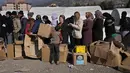 Orang-orang yang kehilangan rumah akibat gempa dahsyat, berbaris untuk menerima pasokan bantuan di kamp darurat, di kota Iskenderun, Turki selatan, Selasa (14/2/2023). Ribuan orang kehilangan tempat tinggal akibat gempa besar yang melanda Turki dan Suriah sepekan lalu, memadati tenda-tenda yang penuh sesak atau berbaris di jalan-jalan untuk makan panas saat pencarian korban selamat yang putus asa memasuki jam-jam terakhir. (AP Photo/Hussein Malla)