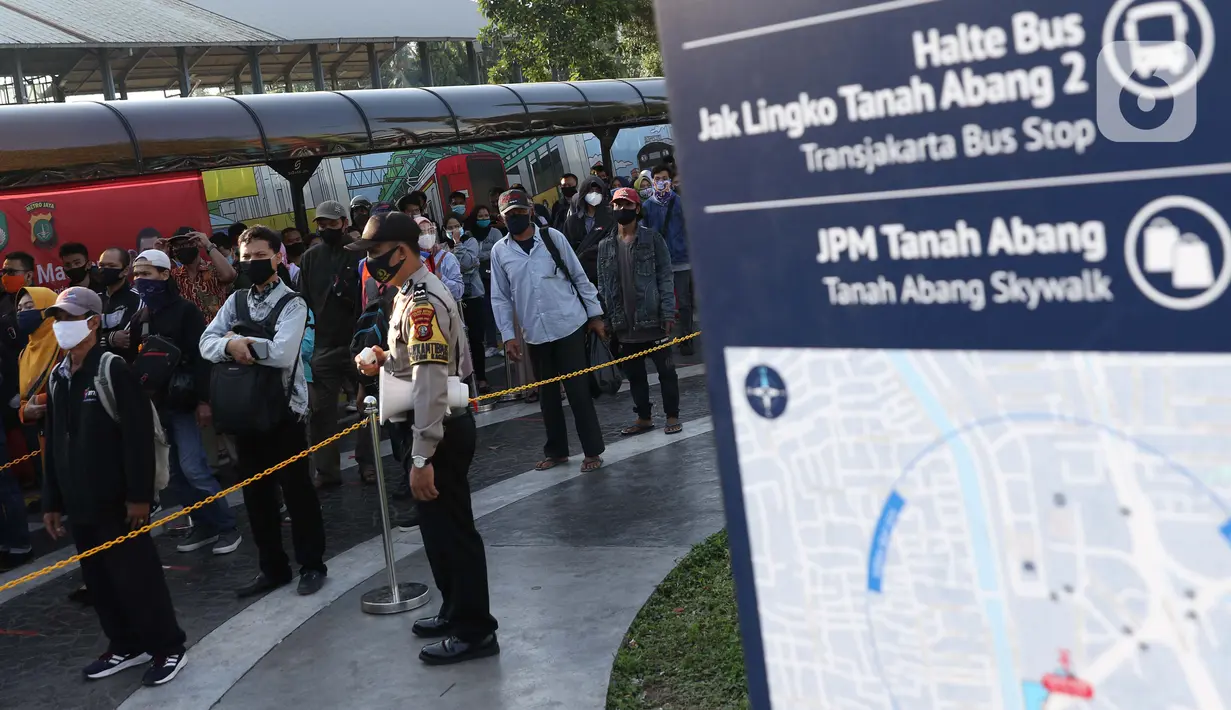Personel polisi mengatur jarak antar calon penumpang kereta di area pedestrian Stasiun Terpadu Tanah Abang, Jakarta, Kamis (27/8/2020). Guna menekan penyebaran Covid-19, Polda Metro Jaya dan Kodam Jaya terus mengampanyekan pentingnya menaati protokol kesehatan. (Liputan6.com/Helmi Fithriansyah)