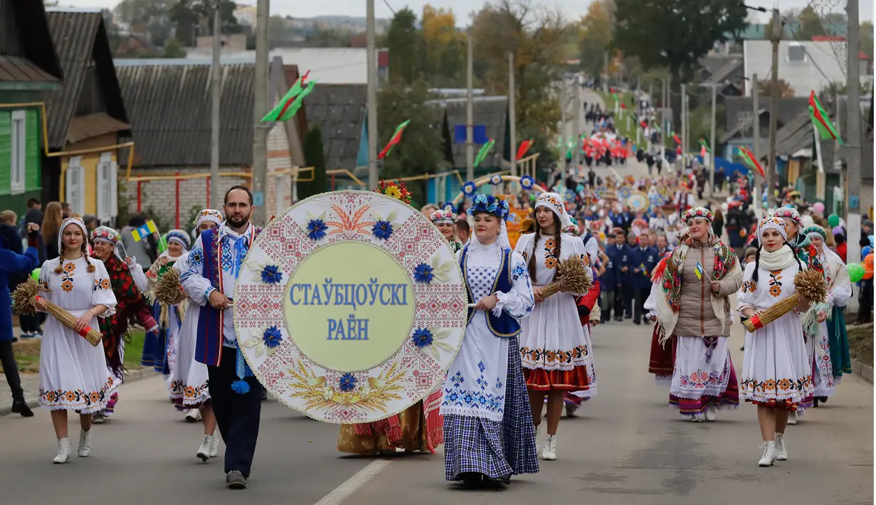 Puluhan warga Belarusia mengenakan pakaian tradisional saat Festival Dozynki berlangsung di Minsk, Belarusia, Minggu (7/10). Tradisi ini sudah dilakukan sejak abad ke-16 di wilayah Eropa Tengah dan Timur. (AP Photo/Sergei Grits)