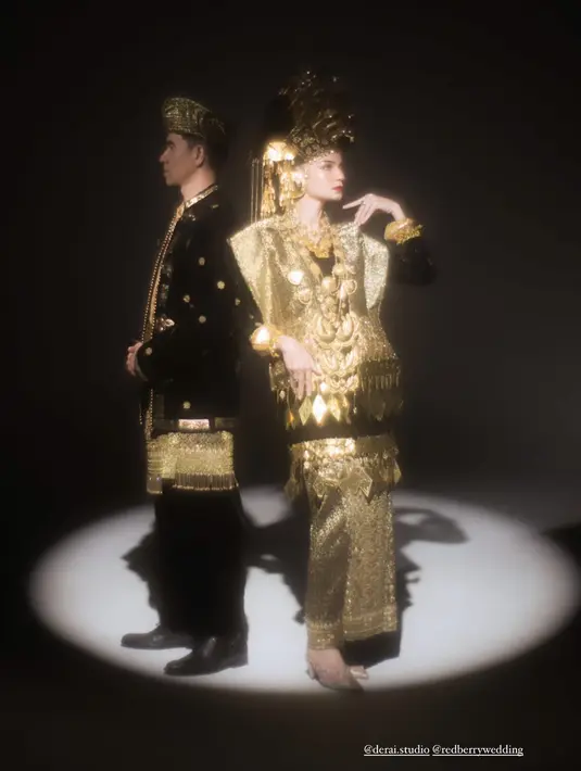 Untuk busana adat, pasangan ini pilih warna hitam emas yang elegan [@enzystoria]