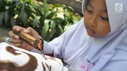 Seorang pelajar mengikuti lomba membatik tingkat SD di Lapangan Ekspresi, Sempur, Bogor, Kamis (2/5/2019). Kegiatan yang diikuti 18 peserta hasil seleksi dari tingkat kecamatan se-Kodya Bogor ini dalam rangka memperingati Hari Pendidikan Nasional yang jatuh pada 2 Mei. (merdeka.com/Arie Basuki)